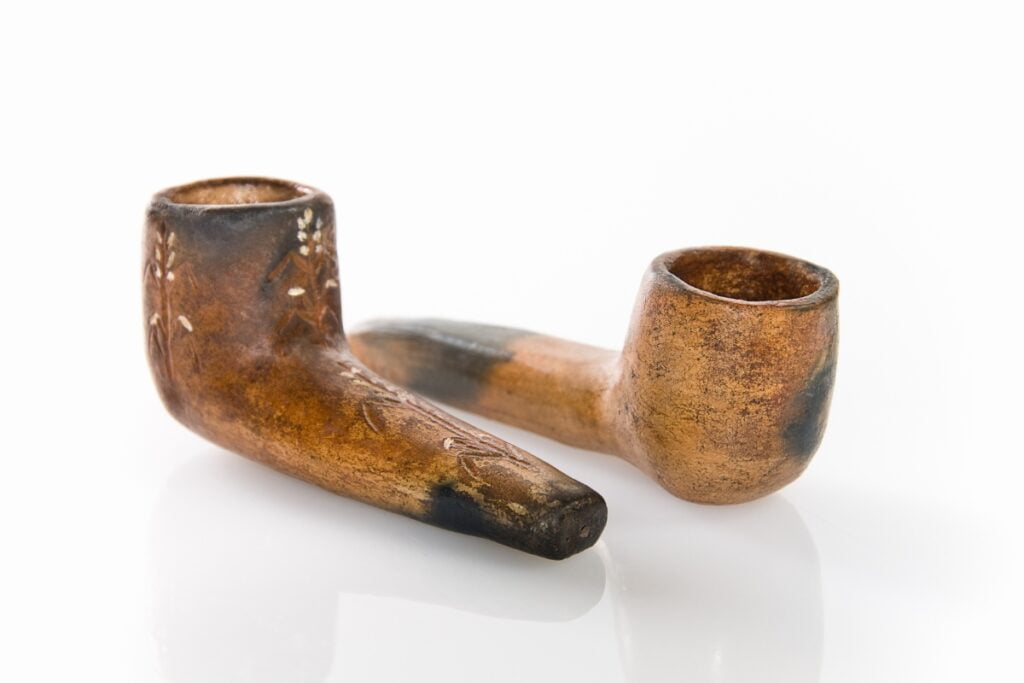 Clay tobacco pipe with wooden stem