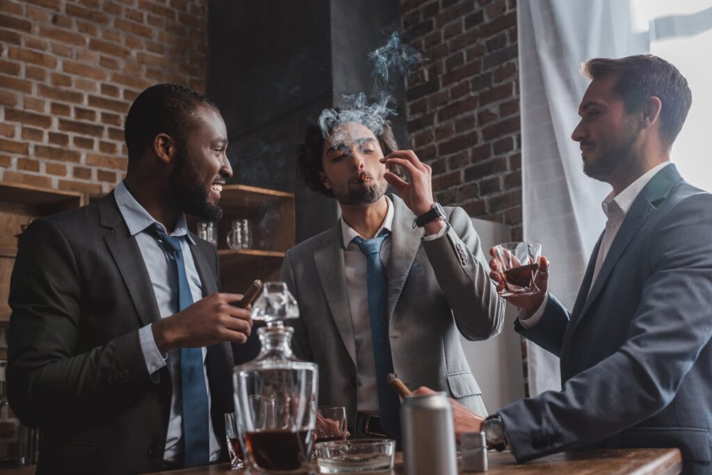 Three cigar aficionados smoking in a bar.