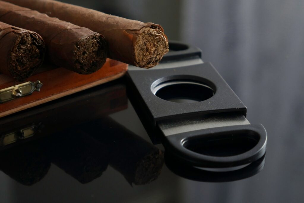 Cigars and a cigar cutter on a table, showcasing the passion of a cigar aficionado.