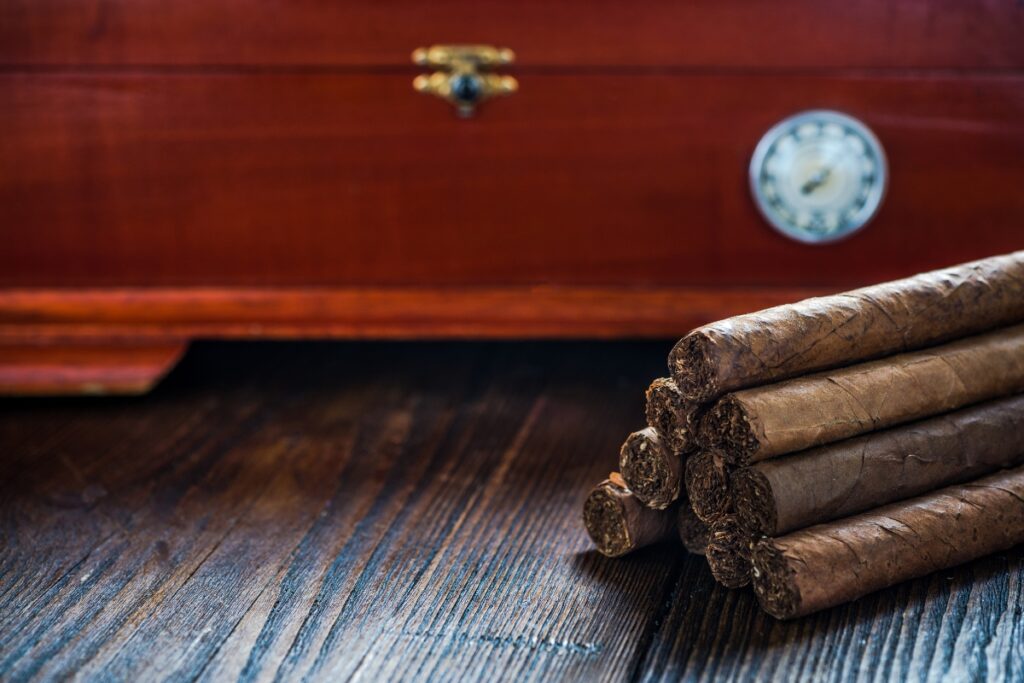 Cigars aging on a wooden table with a clock.