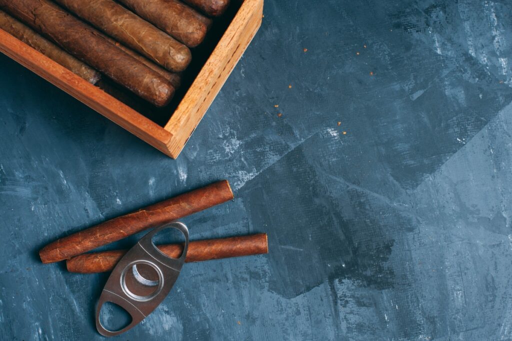 Aging fine cigars in a wooden box on a blue background.