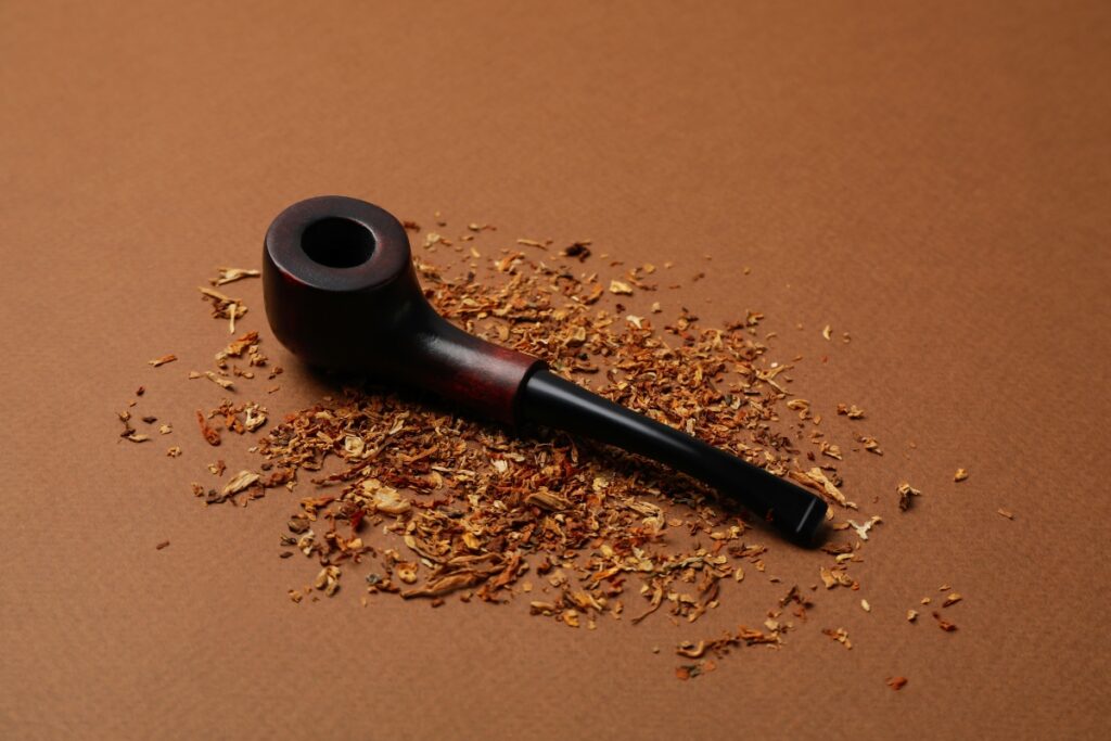 A pipe, symbolizing the rich history of smoking pipes, rests gracefully on a warm brown background.