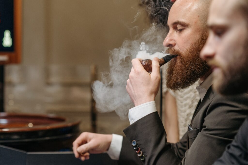A man in a suit displaying pipe smoking etiquette.