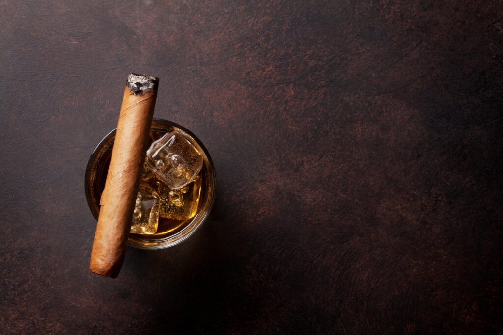 A cigar and a glass of ice for drink pairings.