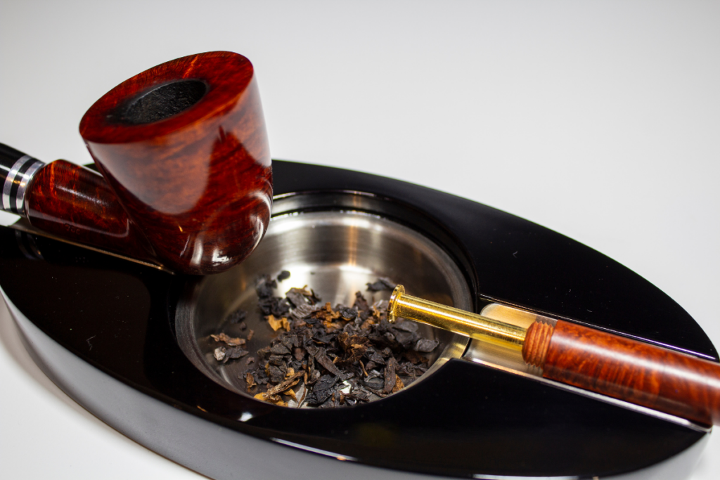 Smoking pipe and tobacco accessories on a black tray.