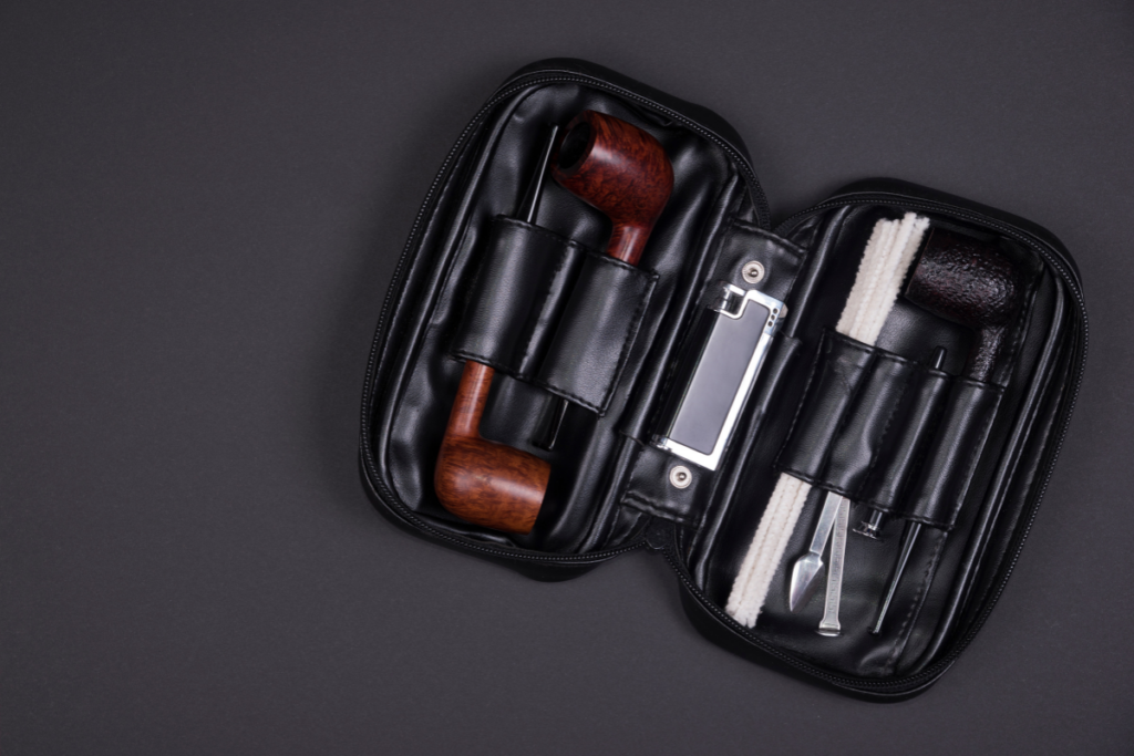 Tobacco pipe smoking accessories kit on a dark background.