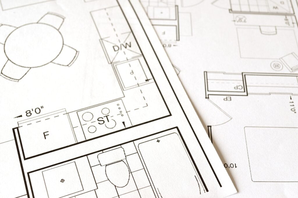 A close-up view of architectural floor plans with detailed sketches of rooms, furniture, a home smoking lounge, and appliances.